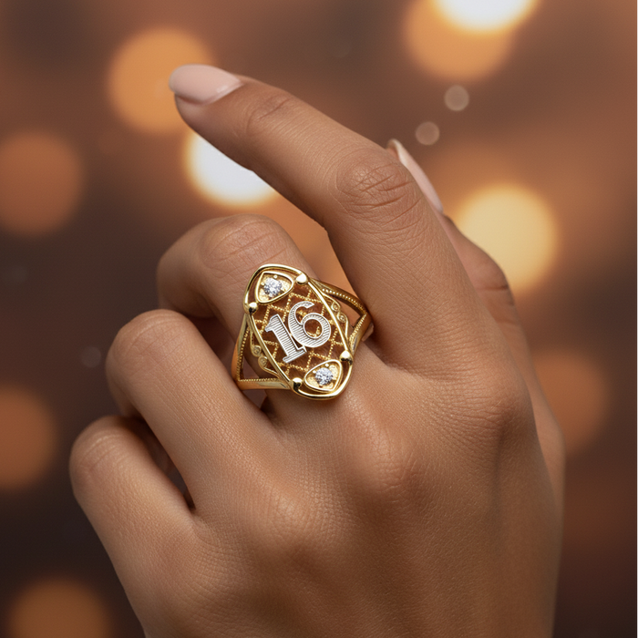 Gold ring with number 16 on a hand against a blurred warm-toned background