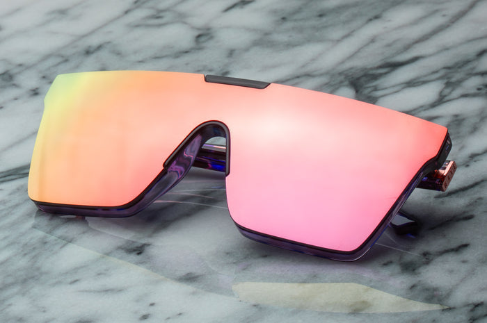 Sitting on a marble table is the Heat Wave Visual Women's Clarity Sunglasses with velvet tortoise frame and rose gold lens.