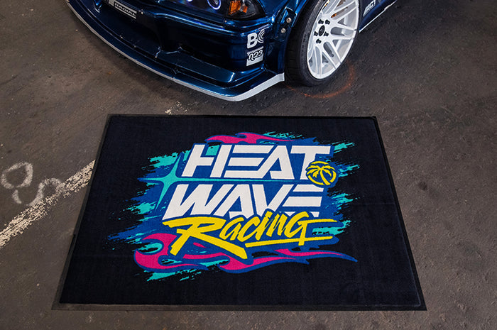 Horizontal Heat Wave Y2K Racing Shop Rug on the floor next to a car