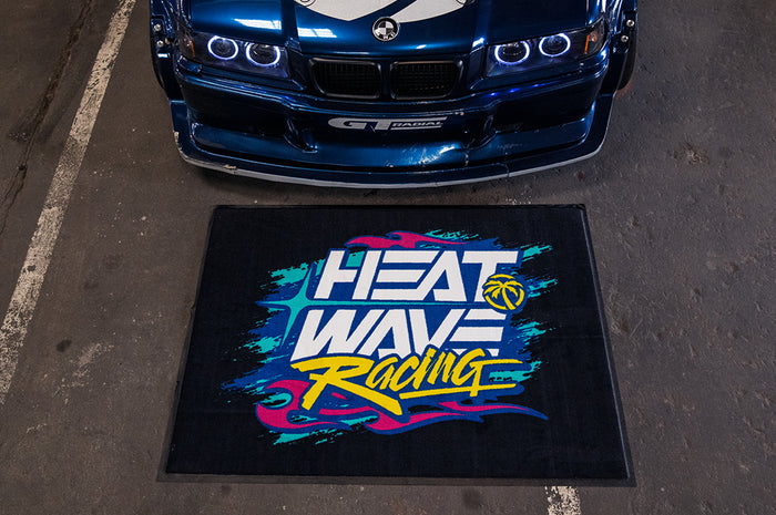 Horizontal Heat Wave Y2K Racing Shop Rug on the floor next to a car