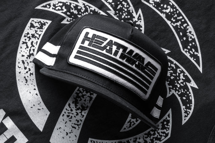 Frontside shot of the Heatwave Alloy Hat lying on top of the Alloy shirt.