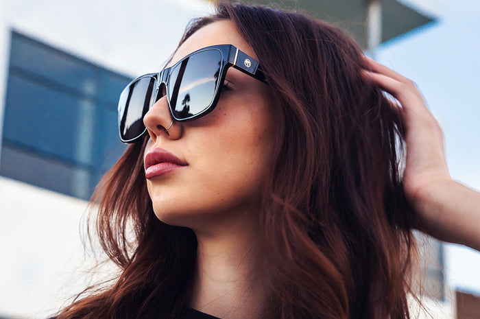 Young women outside wearing the Heat Wave Visual Marylin Sunglasses with black frame and ultra black lenses.
