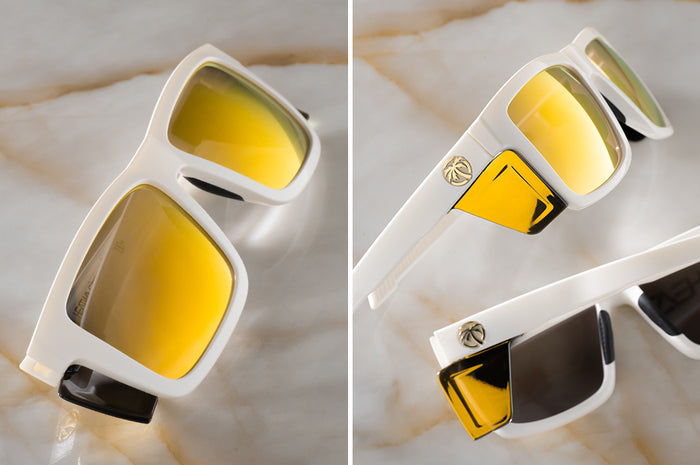 Two pairs of the Performance Vise Sunglasses: GLOSS WHITE Gold Lens Z87+ on a counter