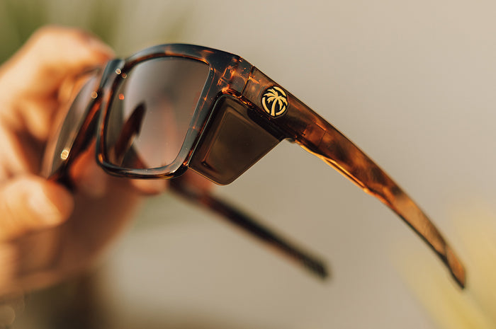 Someone hold up the Heat Wave Visual Performance Vise Sunglasses with tortoise frame, brown lenses and matching side shields.