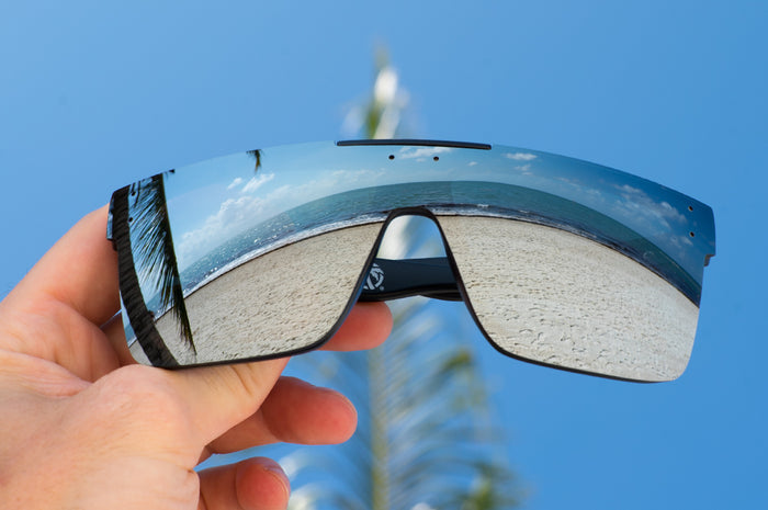 Heat Wave Visual Quatro Sunglasses with black frame and silver lens at the beach.