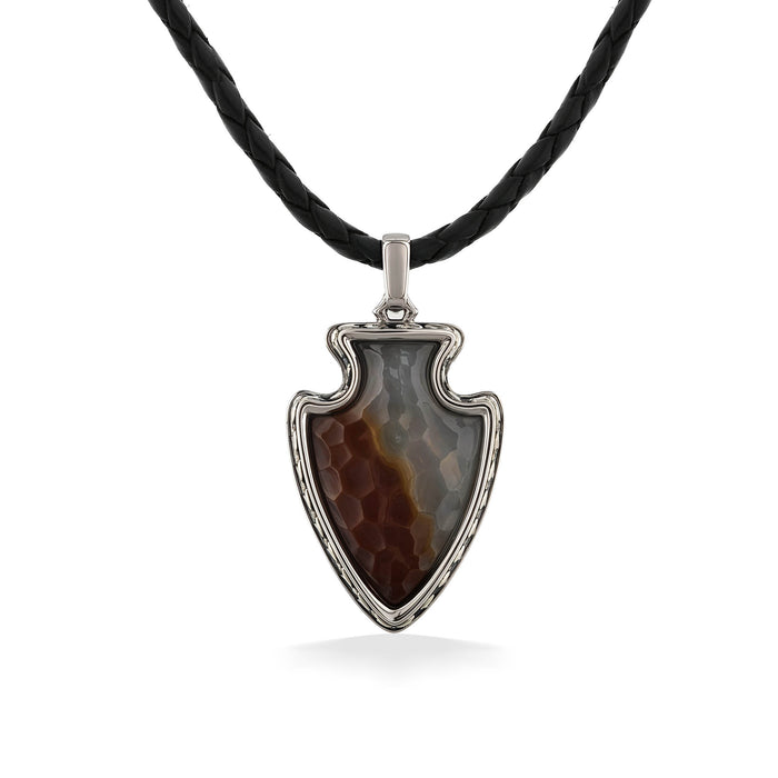 A pendant shaped like an arrowhead with  brown & gray stone in a silver frame, hung on a black leather cord. Item No. 45305