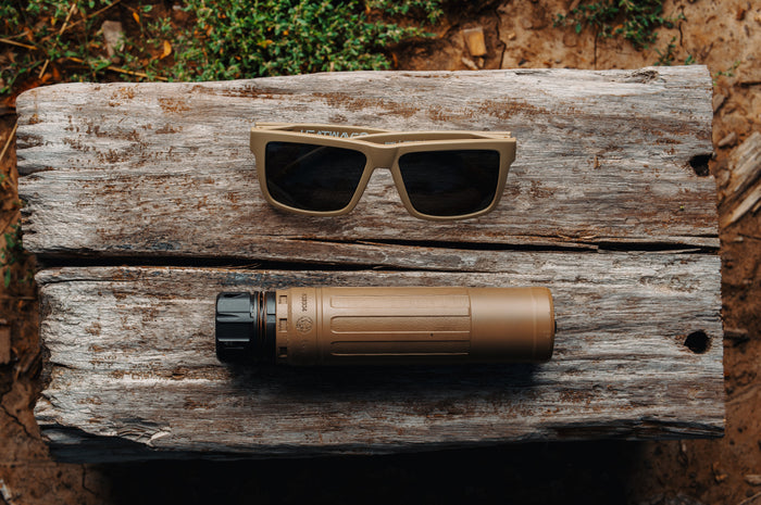 The  VISE Z87 Sunglasses DESERT TAN: Black Lens on a wooden log