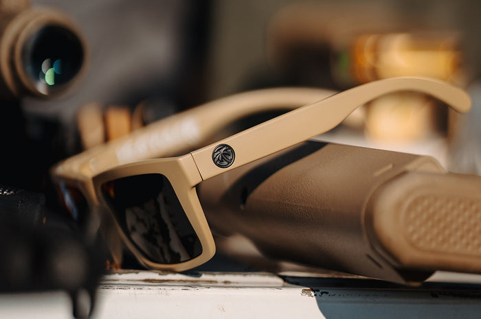 3/4 angle of the XL VISE Z87 Sunglasses DESERT TAN: Black on a table with accessories